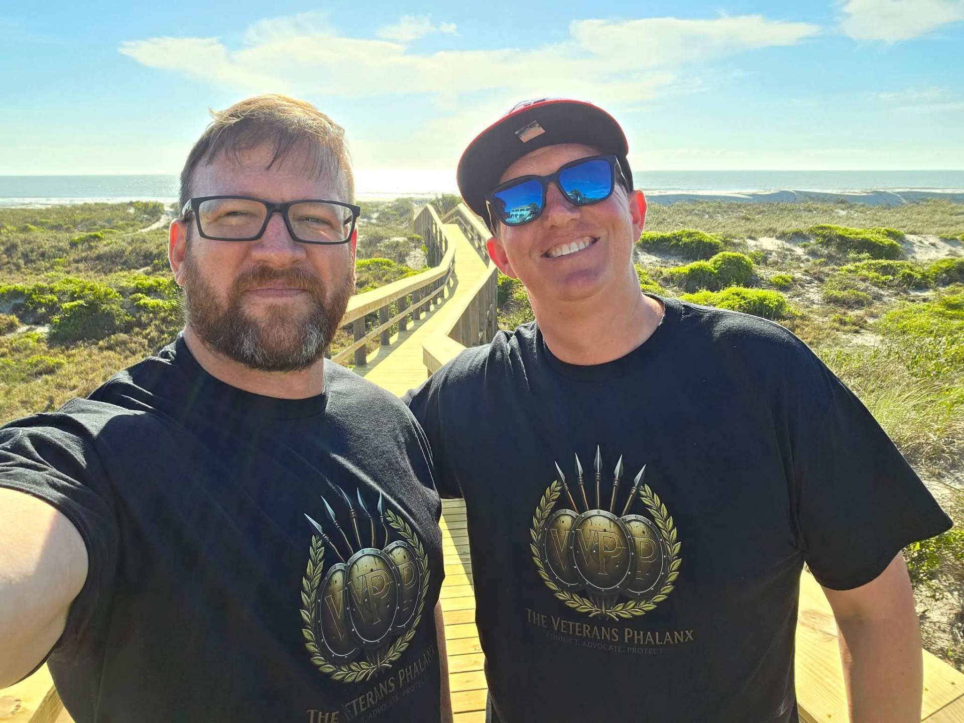Two Veterans Phalanx members on the dune boardwalk heading to the United on The Sand beach yoga event.